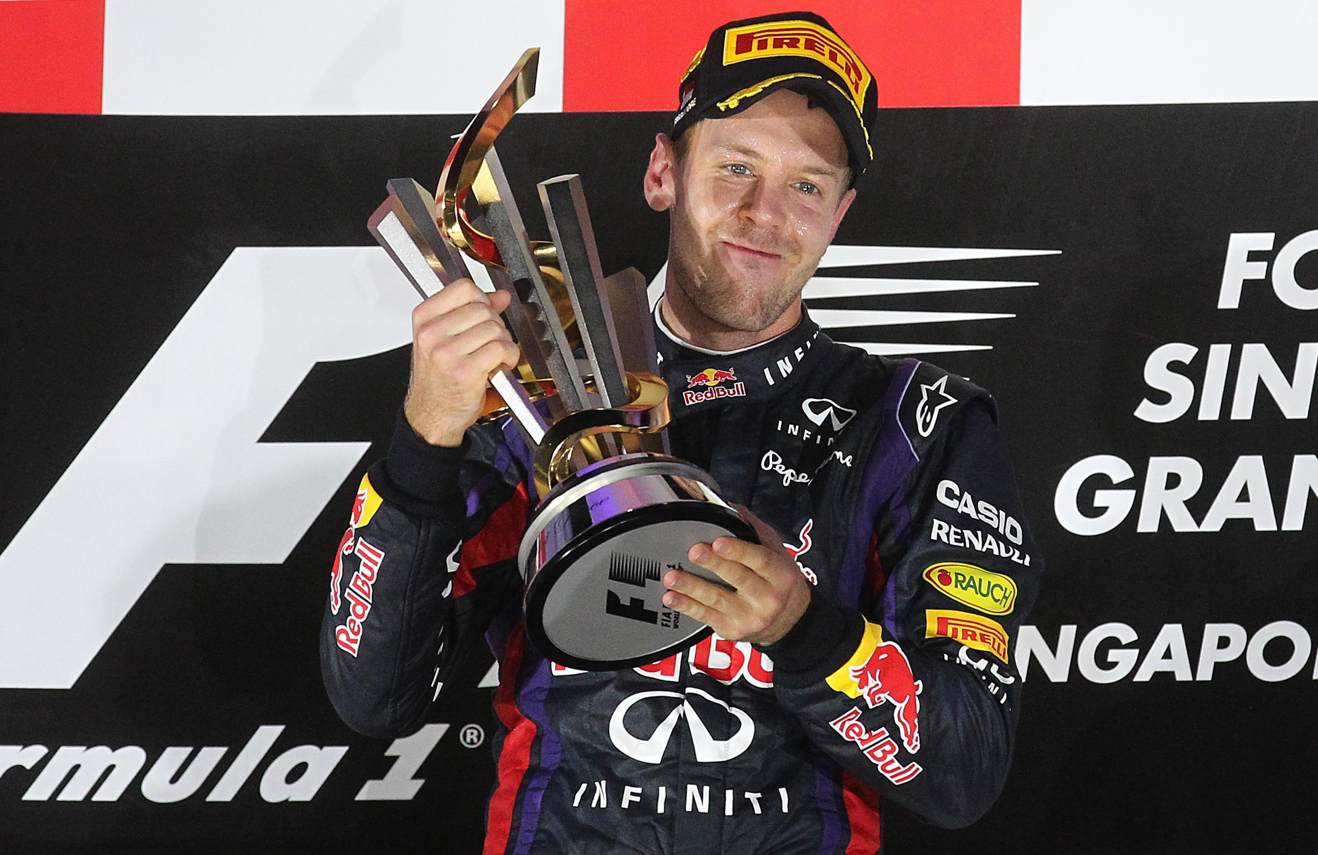 Red Bull driver Sebastian Vettel of Germany celebrates on the podium after winning the Singapore Formula One Grand Prix on the Marina Bay City Circuit in Singapore, Sunday, Sept. 22, 2013.(AP Photo/Wong Maye-E)